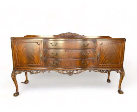 A 20th century Chippendale style carved mahogany twin pedestal dining table with a matching sideboard
The table with a rounde