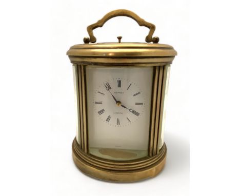 A modern brass oval striking and repeating carriage clock retailed by Asprey, London
The shaped handle over bevelled glass pa