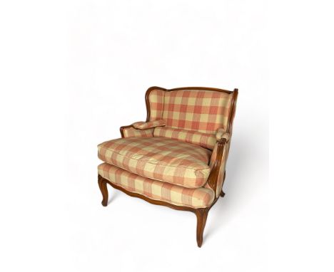 A large Louis XV style stained beechwood wing bergere armchair
Upholstered in pink check fabric, the rectangular padded back,