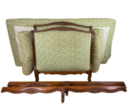 A Louis XV style carved beechwood single bed
Upholstered in green and white leafy cotton print, the scrolling head and tailbo