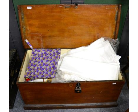 A wooden blanket box containing a quantity of linen together with another trunk