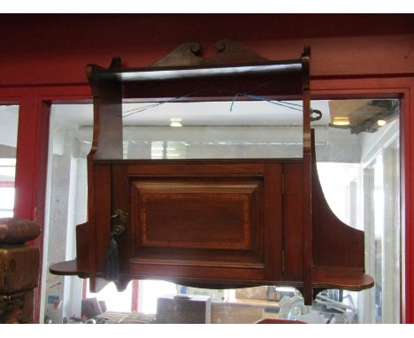 An Arts &amp; Crafts Maple &amp; Co. crossbanded mahogany wall hanging shelf/cabinet stamped 144 the single panel door having