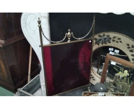 A Regency style brass fireguard with urn and swag cranberry glass panel 