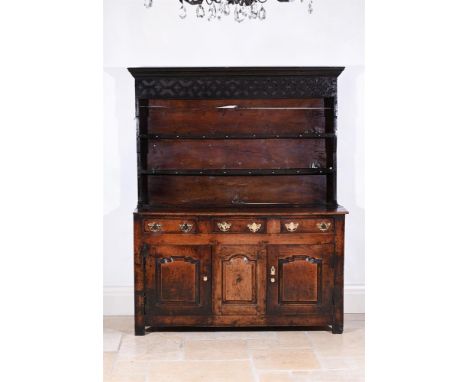 AN OAK DRESSER  COMPRISING ASSOCIATED MID 18TH CENTURY AND LATER ELEMENTS The plate rack superstructure with unusual fretwork