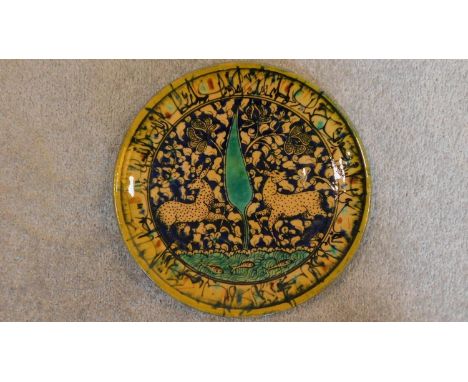 A Persian glazed ceramic plate, decorated deer amid naturalistic setting, dated and marked to base. 4x28cm