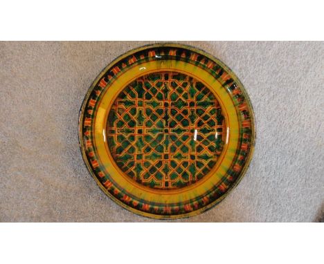 A Persian glazed ceramic bowl decorated in a geometric pattern, dated and marked to base. 7x28cm