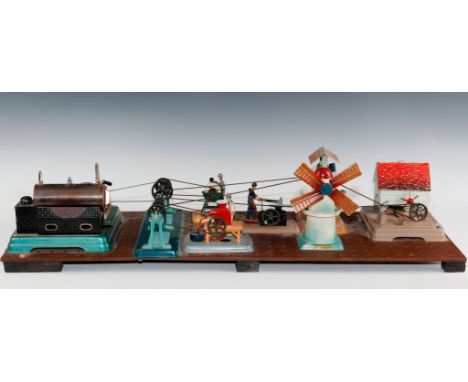 Tinplate toys powered by a cable drive connected to steam engine.A vintage Fleischmann tin steam engine toy set affixed to a 