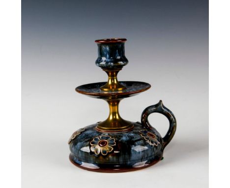 Raised relief decoration of five flowers.A Doulton Lambeth candlestick holder with floral decoration and brass metal fittings