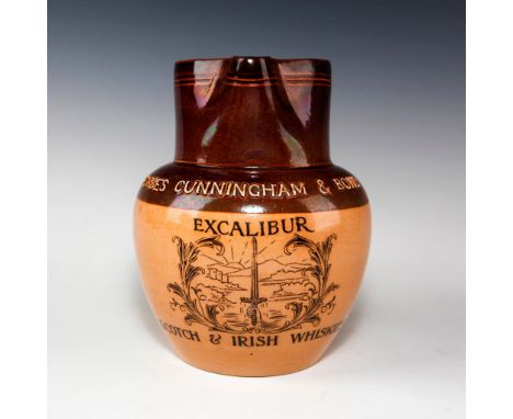 Two-tone tan salt glaze, with rear handle.Designed with mountain scene background. Inscribed EXCALIBUR SCOTCH &amp; IRISH WHI