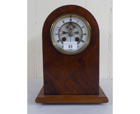 An early 20thC mahogany and walnut finished, cased mantel clock; the 8 day movement faced by a skeleton and Roman dial&nbsp; 