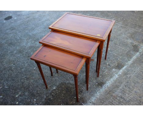 A nest of three yew occasional tables, on turned supports, 23" wide, a yew lamp table, 20" wide, and a yew dressing stool, 20