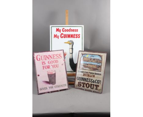 A Guinness enamel advertising sign and two other similar signs 