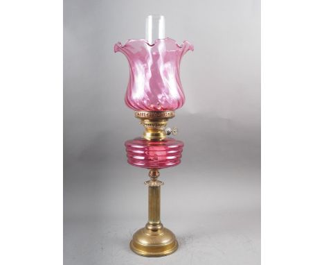 A Victorian oil lamp with pink glass shade and reservoir, on fluted column and circular base, 23 1/4" high overall 