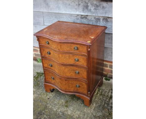 A 1930s burr walnut serpentine front chest of four drawers with ring handles, on bracket feet, 24" wide x 19" deep x 30" high