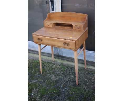 A 1960s Ercol elm and beech writing table, 437/439, with stationery compartments over one long drawer, on splay supports, 27"