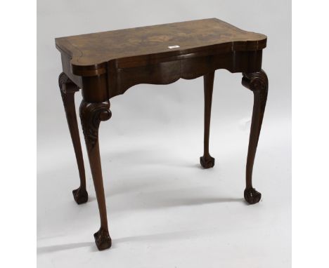 Early 20th Century walnut card table, the fold-over top with baize lined interior on carved cabriole claw and ball supports, 