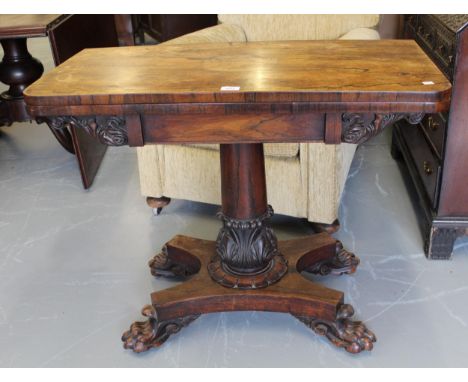 William IV rectangular rosewood fold-over card table on carved turned column and quadruped support with lions paw feet 