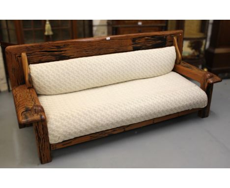 Modern low exotic hardwood sofa (possibly reclaimed railway sleepers), the back and seat cushions a cream stylised floral fab