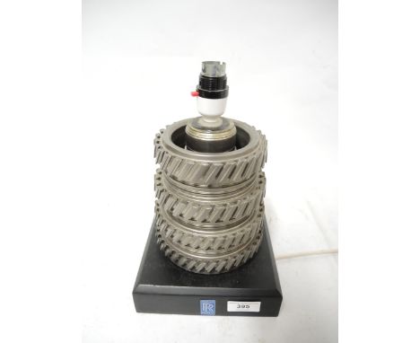 Modern table lamp constructed from gear box cog wheels, the ebonised plinth base with Rolls Royce label, 20cm high 