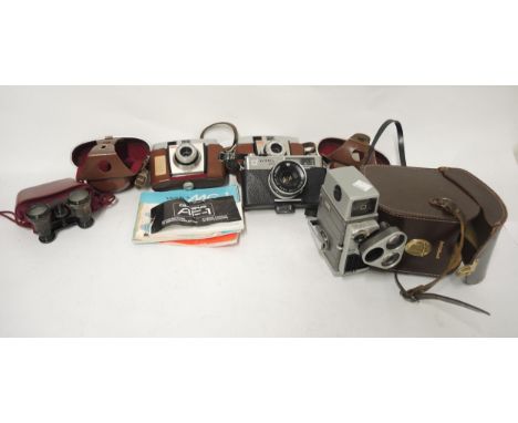 Pair of opera glasses in partial leather case, three various cameras and a Bell & Howell cine camera in travel case 