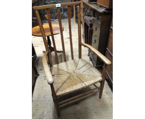 Arts and Crafts beechwood slat back open elbow chair with rush seat, together with a wickerwork hamper 