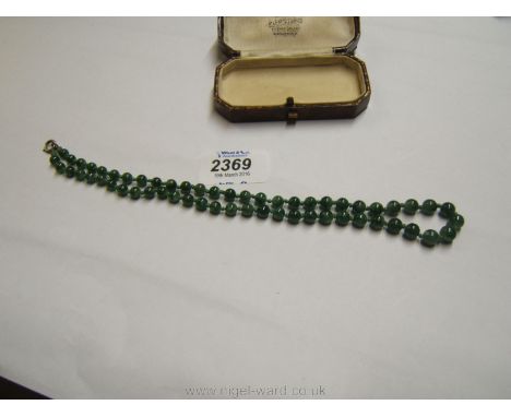 A pretty Jade graduated bead Necklace, with a letter of authentication from 'The Jade Store & Co.', 1932. 57 beads. 18 1/2'' 