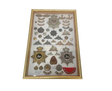 Fine collection of Victorian and later Lincolnshire Regiment badges and button including three helmet plates in glazed frame.