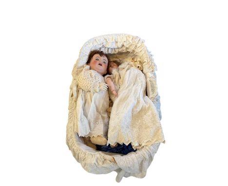 A charming group of three antique dolls together with a facsimile photograph of the original owner (born in 1913) as a child 