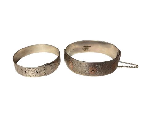 1960s silver hinged bangle with floral decoration (Birmingham 1962), together with a sterling silver buckle-style bangle (2)T