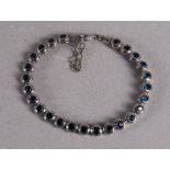Een 1e gehalte zilveren tennisarmband met facetgeslepen blauwe steentjes.