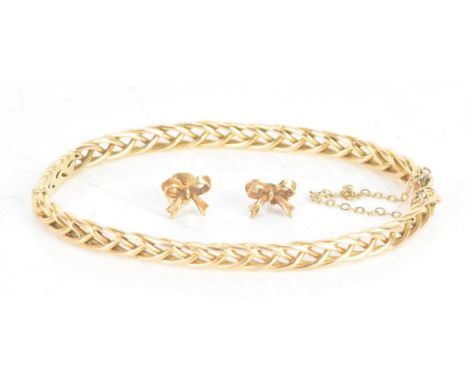 A yellow metal bangle, having a box clasp with a pierced woven design, unmarked, 11.5 grams, together with a pair of 9ct gold