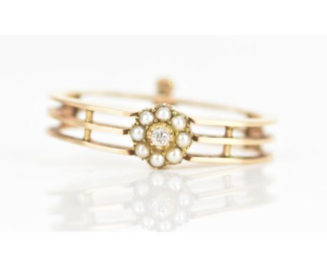 A Victorian diamond and pearl yellow gold scarf clip, the brilliant cut diamond approximately 2mm, surrounded by a halo of se