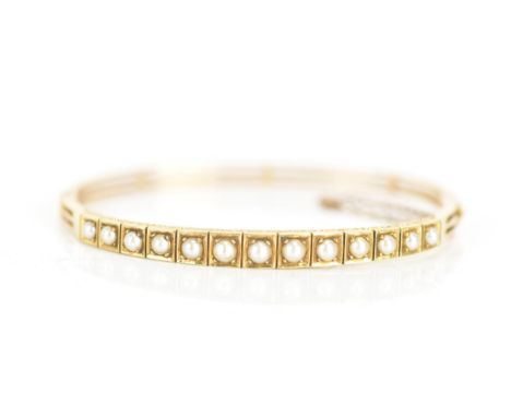 A Victorian 15ct gold bangle, inset with thirteen pearls in claw settings, the gallery engraved with a scroll design, box cla