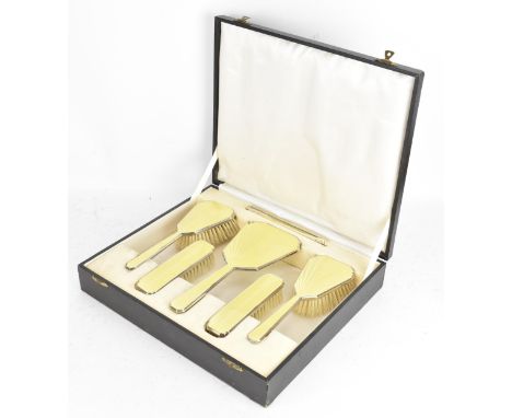 A George V cased silver and yellow guilloche enamel dressing table set by Henry Clifford Davis, hallmarked Birmingham 1933, c