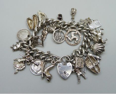 A silver charm bracelet with a collection of silver, white metal and plated charms including a silver Nuvo driving licence, a