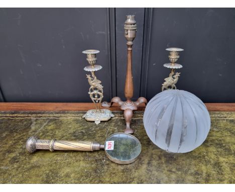 A pair of brass pheasant candlesticks, 23.5cm high; together with a large magnifying glass; and a patinated brass tripod carr