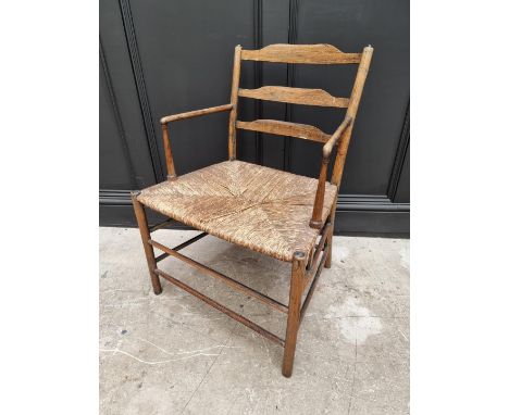 An antique ash and rush seated Sussex style elbow chair, with ladder back. 