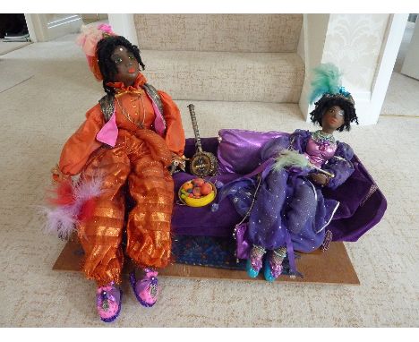 Hand crafted papier mache one off design of a couple of ladies lounging on a sofa designed and created by Margaret Hickson (M