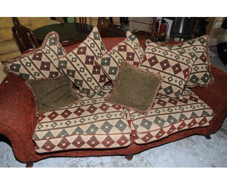 Large two seat sofa on raised wood supports with loose scatter cushions 