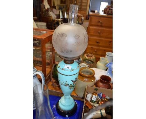 Victorian oil lamp with frosted glass shade and with an eggshell blue glass font decorated with birds and foliage