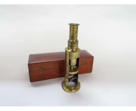 A late 19th/early 20th Century compact brass monocular field microscope of telescopic form, adjustable tube, single lens, in 