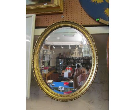 An oval gilt mirror
