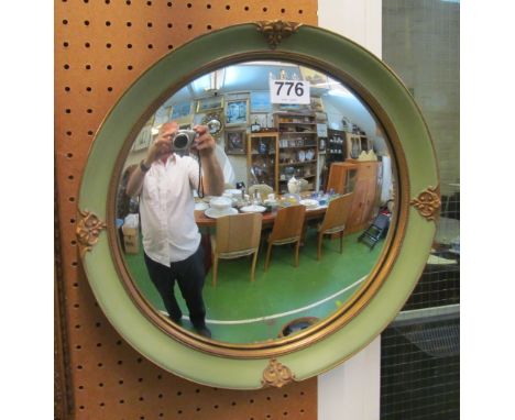 A convex mirror in green and gilt frame