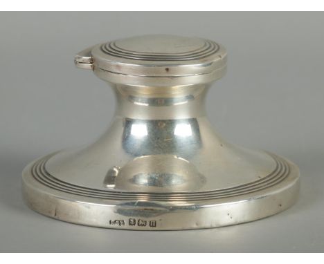A silver filled capstan inkwell, with polished wooden base, hinged top and concentric circle decoration. Assayed for Birmingh