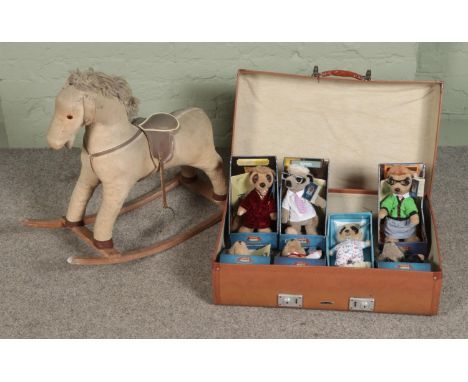 A vintage child's rocking horse along with a suitcase containing an assortment of Compare The Meerkat toys.  