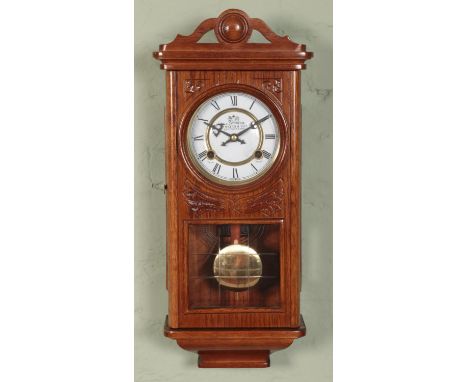 An oak cased wall clock by P Watts &amp; Son chiming on a coiled gong.  Working order.