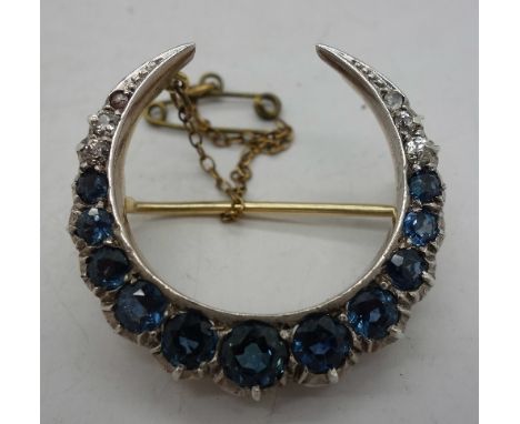 A sapphire and diamond set half-moon shaped brooch, in yellow metal