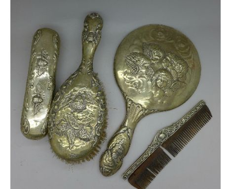 A three piece silver backed mirror and brush set decorated with cupids and a comb, comb a/f