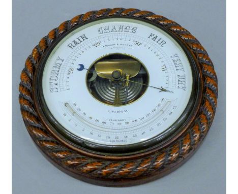A Victorian oak rope twist aneroid barometer. 27 cm diameter.