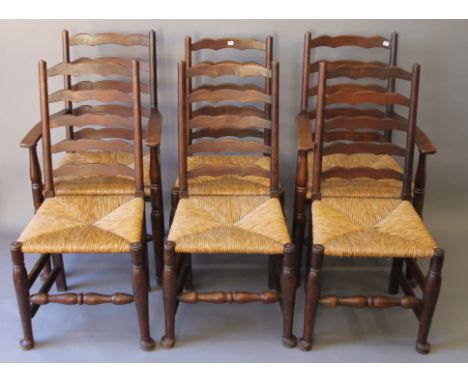 A set of six oak rush-seated ladder-back chairs. The carvers 55 cm wide.